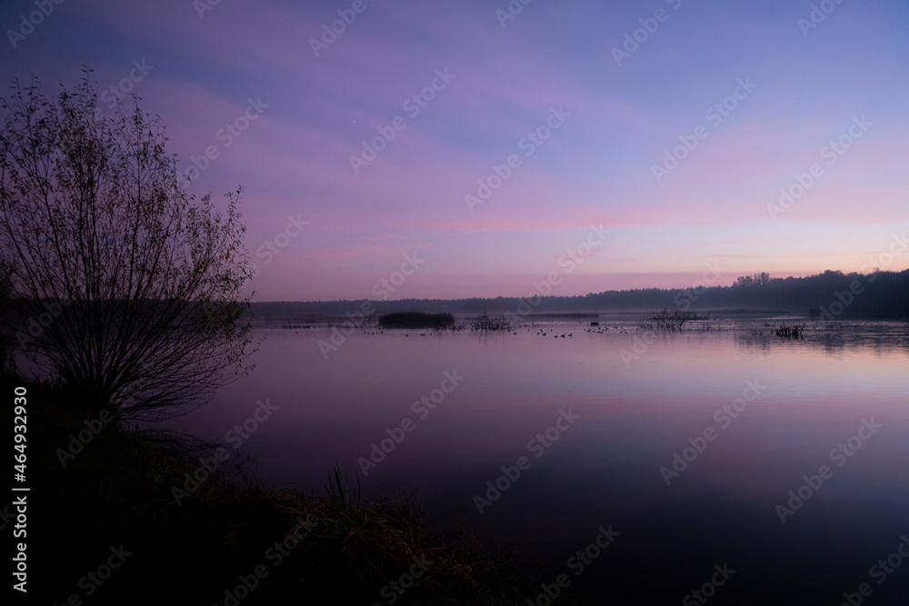 Klimatyczny zachód słońca nad jeziorem, jezioro w kolorach zachodzącego słońca
