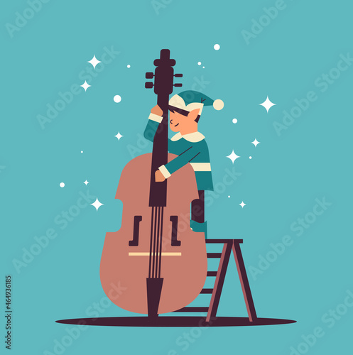 elf in uniform with musical instrument boy santa helper playing violin happy new year christmas holidays
