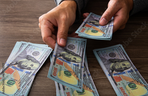 Man counting paper dollar banknotes. 100 usd dollar bills in hands close up.