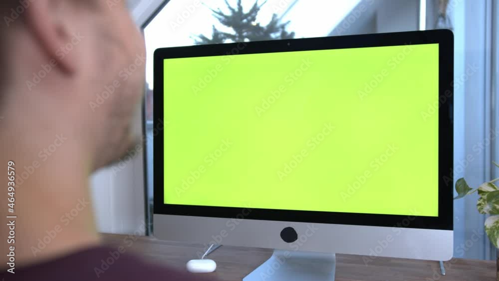 Caucasian Young Man using Green Screen on imac or computer in home office. Concept for online course, e learning, business to replace screen. Caucasian Young Man using Green Screen on imac or computer in home office. Concept for online course, e learning, business to replace screen.