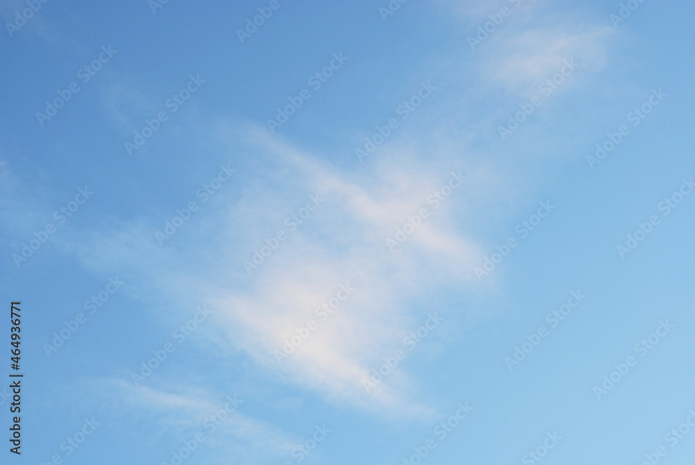 Moving cloud illuminated by  evening light in blue sky atmosphere. Abstract nature blurred background.