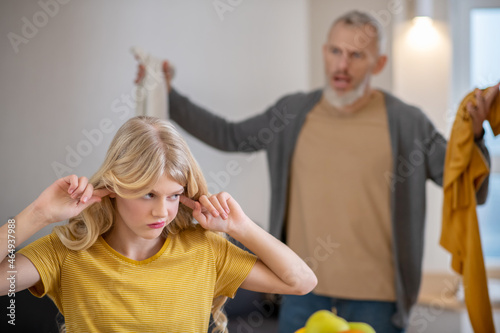 A blonde cute girl feeling frustrated while her father shouting at her
