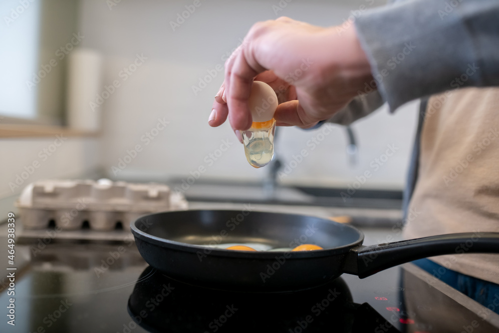 A gray-haired man cooking omlette in the kitchen A gray-haired man cooking omlette in the kitchen
