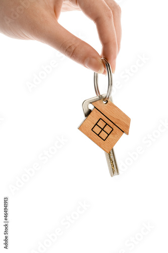 Woman holding key with house shaped keychain on white background, closeup