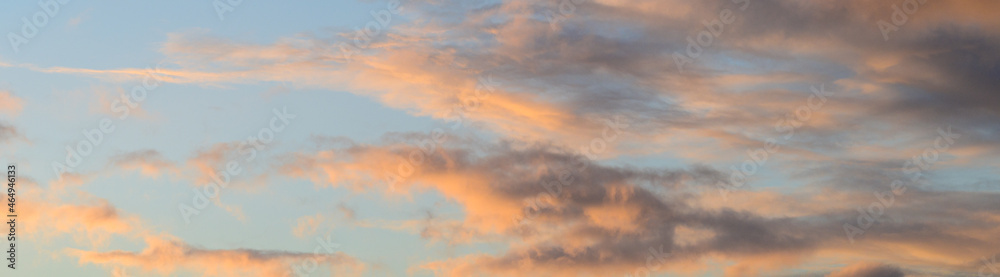 Dramatic sunset with light blue sky and colorful bright clouds, as a nature background

