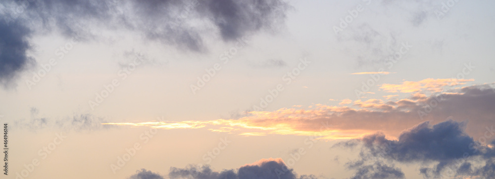 Moody dark clouds and long cloud with bright highlights, as a nature background
