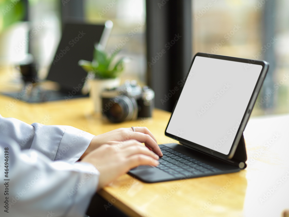 Elegant businesswoman remote working at coffee shop, working on digital portable tablet