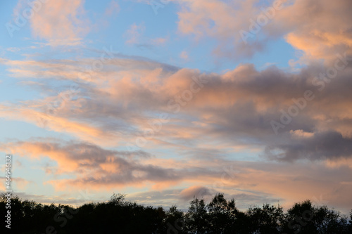 Fluffy ethereal pastel clouds lighted by the fading sun  as a nature background 