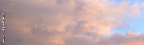 Fluffy ethereal pastel clouds lighted by the fading sun, as a nature background
