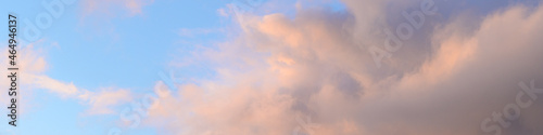 Fluffy ethereal pastel clouds lighted by the fading sun, as a nature background 