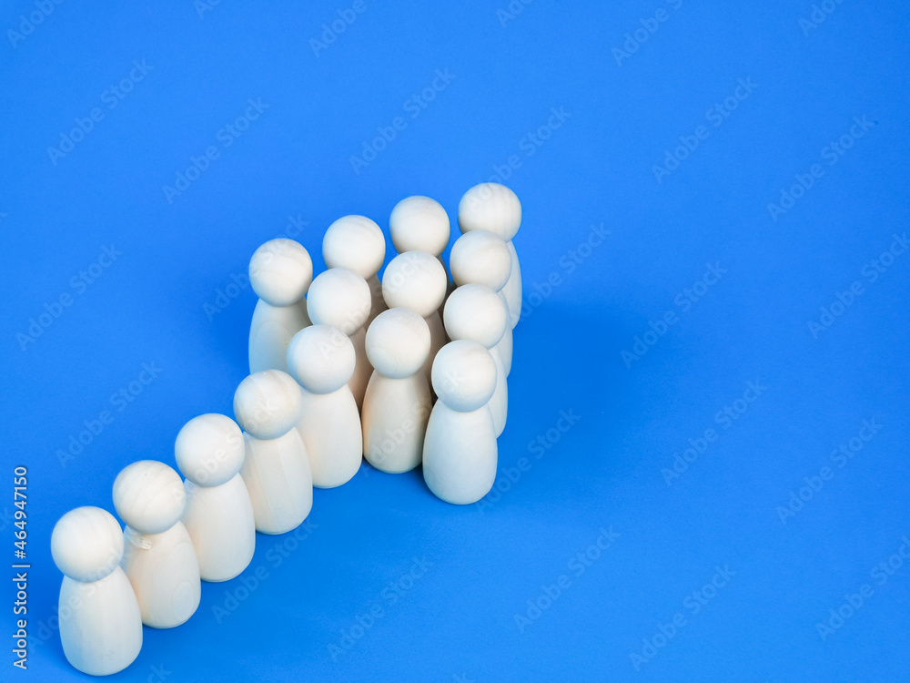 Wooden dolls group in arrow shape. Strength in unity and teamwork concept. Wooden dolls group in arrow shape. Strength in unity and teamwork concept.
