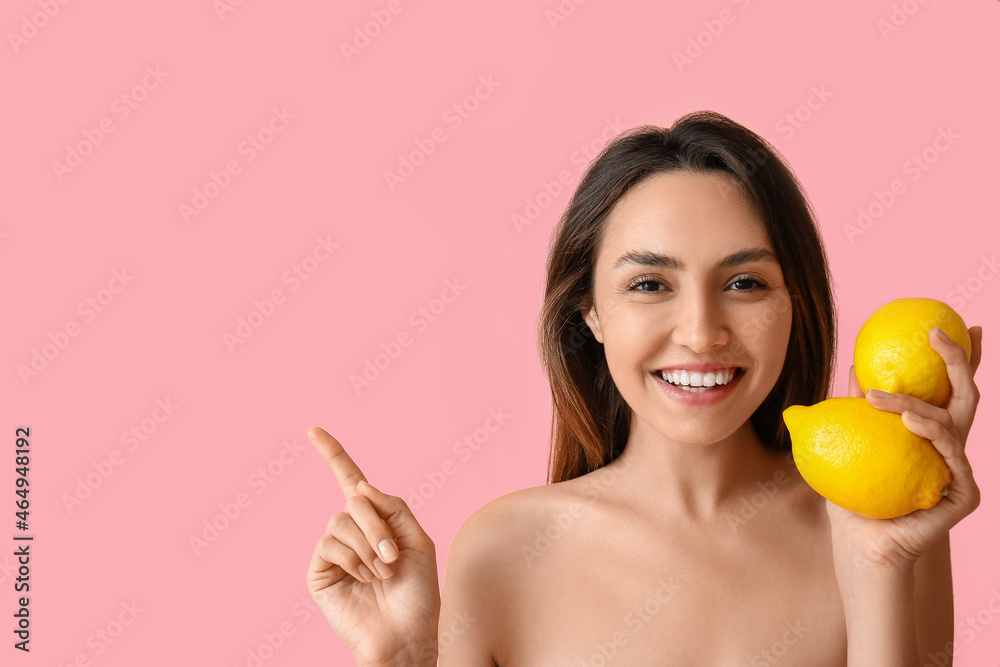 Naked young woman with fresh lemons showing something on color background. Vegan Day Naked young woman with fresh lemons showing something on color background. Vegan Day