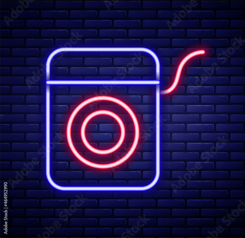 Glowing neon line Dental floss icon isolated on brick wall background. Colorful outline concept. Vector