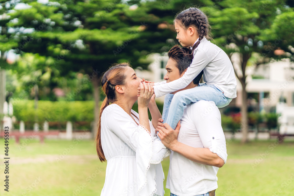 Portrait of enjoy happy love asian family father and mother holding hug cute little asian girl child smiling playing and having fun moments good time in summer park at home Portrait of enjoy happy love asian family father and mother holding hug cute little asian girl child smiling playing and having fun moments good time in summer park at home
