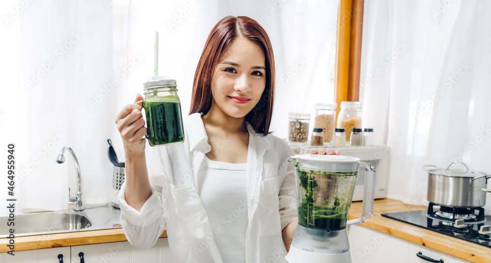 Healthy beauty asian woman enjoy making green vegetables detox cleanse and green fruit smoothie with blender in kitchen at home.dieting concept.healthy lifestyle Healthy beauty asian woman enjoy making green vegetables detox cleanse and green fruit smoothie with blender in kitchen at home.dieting concept.healthy lifestyle