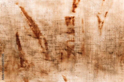 The texture of an old linen cloth, covered with dirt and rust. Background grange. The rusty fabric is streaked.
