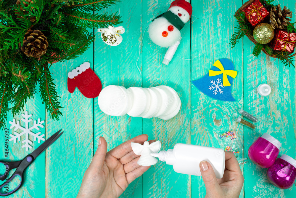 Fototapeta premium Create a children's Christmas gift with a little angel toy made of cotton pads. Children's art project, handicrafts, handicrafts for children. Step-by-step instruction. Step 13