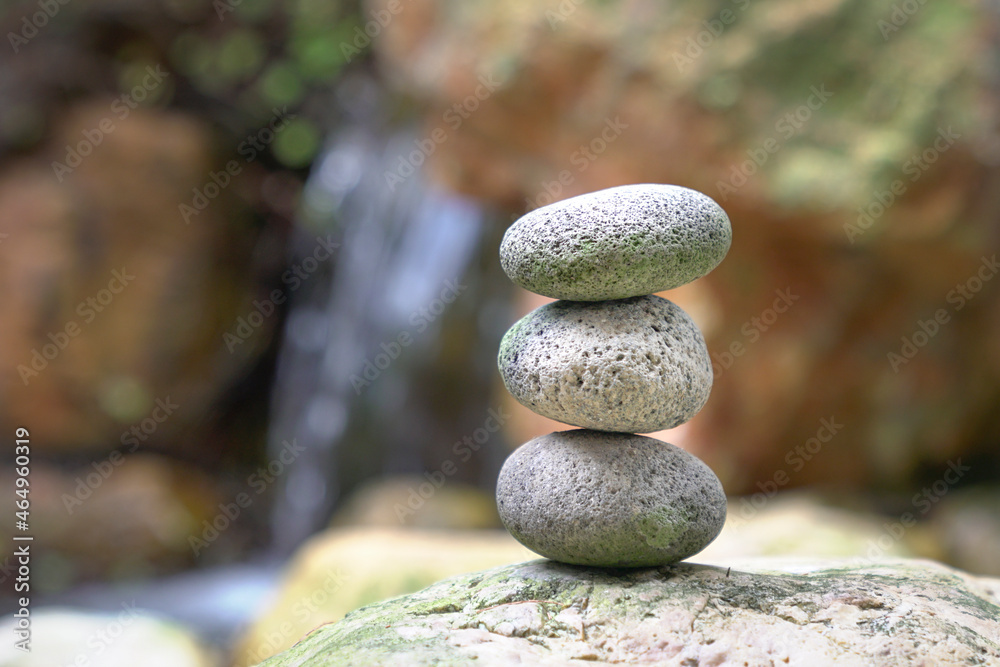 Stones stacked on top of each other with mini waterfall at the background. Balance, zen and harmony concept. Stones stacked on top of each other with mini waterfall at the background. Balance, zen and harmony concept.