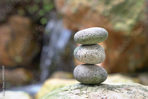 Stones stacked on top of each other with mini waterfall at the background. Balance, zen and harmony concept.