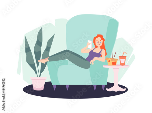 Redhead girl sit in an armchair using her phone for surfing online and eating chinese takeout food