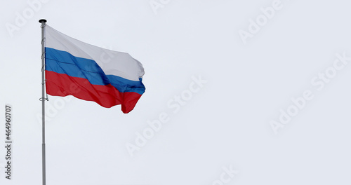 Russia flag on gray cloudy sky.