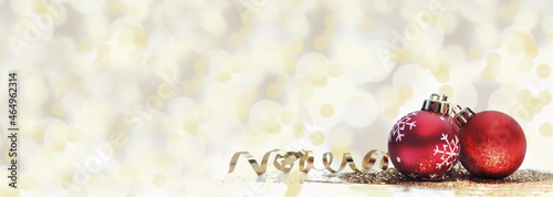 red christmas balls in glitters and golden ribbon on blur light background