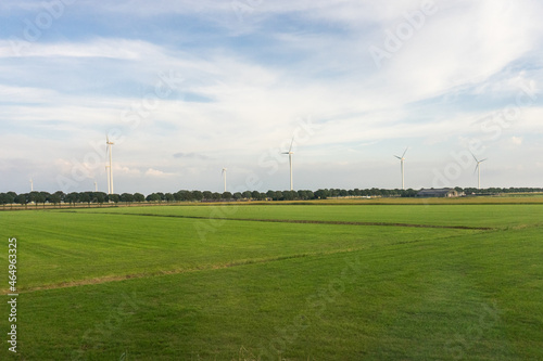 Antwerp, Belgium, a large green field with trees in the background windmills