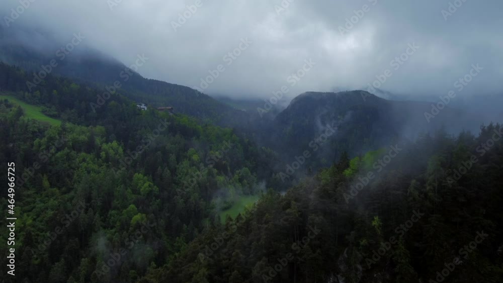 Flying over a forest and approaching a mountain hut on a rainy day in the Italian Dolomites Flying over a forest and approaching a mountain hut on a rainy day in the Italian Dolomites