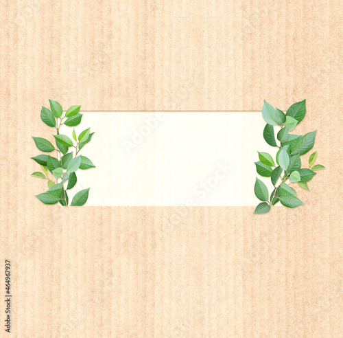 Green leaves on cardboard texture. Vertical banner with eco paper texture