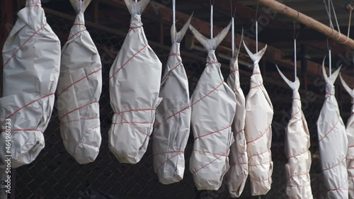 dryied salted fish hanging up wraped in newspaper in Thailand photo