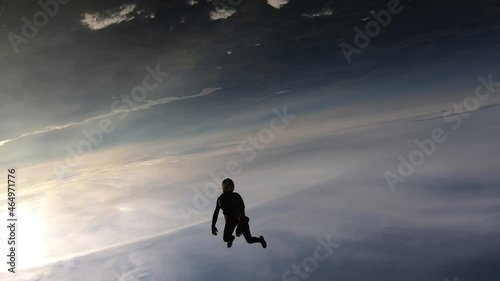 Freefly skydiving. Happy girl is flying in the sunset sky.