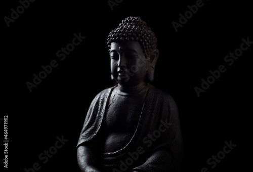 Meditating Buddha Statue isolated on black background. Copy space.	