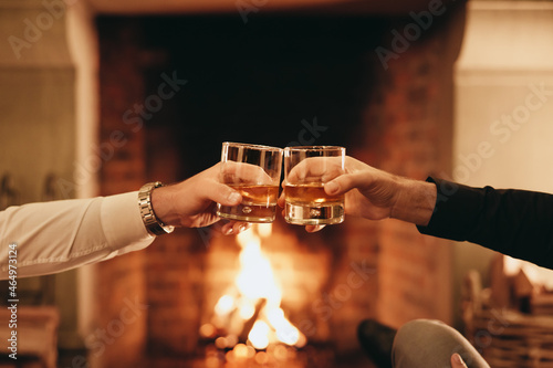 Two hands toasting with whiskey glasses