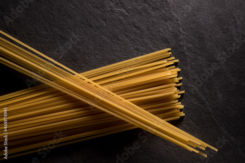 Spaghetti en deux tas croisés, cru , sur fond d'ardoise