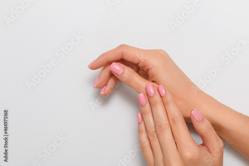 Beautiful hands of a woman with manicure isolated on a light gray background. Skin care concept. Close-up.