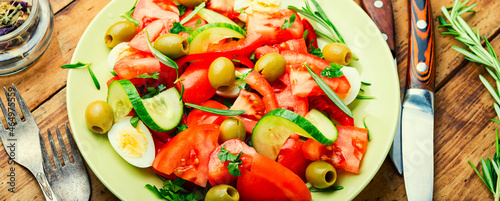 Salad with vegetables, olives, eggs and rosemary