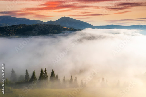 Aerial view of foggy sunrise in the mountains. Summer mountains.