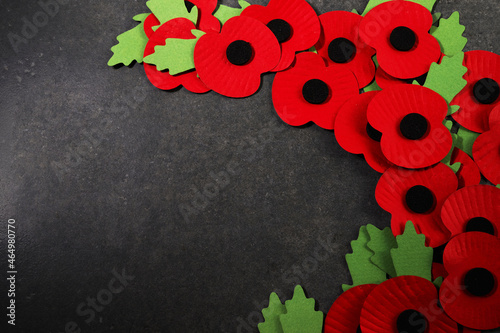World War remembrance day. Red poppy is symbol of remembrance to those fallen in war. Red paper poppies on dark stone background photo