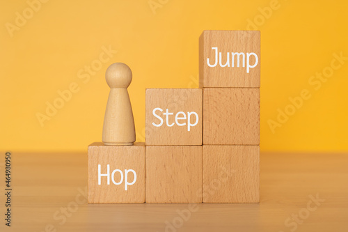 「Hop Step Jump」と書かれた積み木と人形