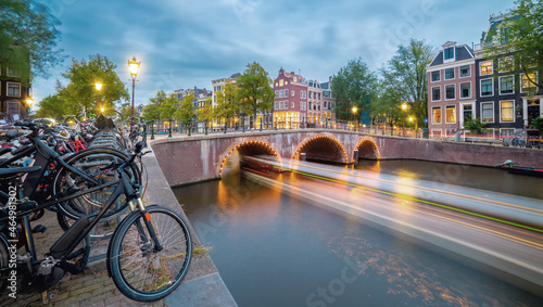 Evening in Amsterdam. Panoramic views of the famous old houses, bicycles, bridge and canal in the old center. Long exposure. Amsterdam, Holland, Netherlands, Europe.