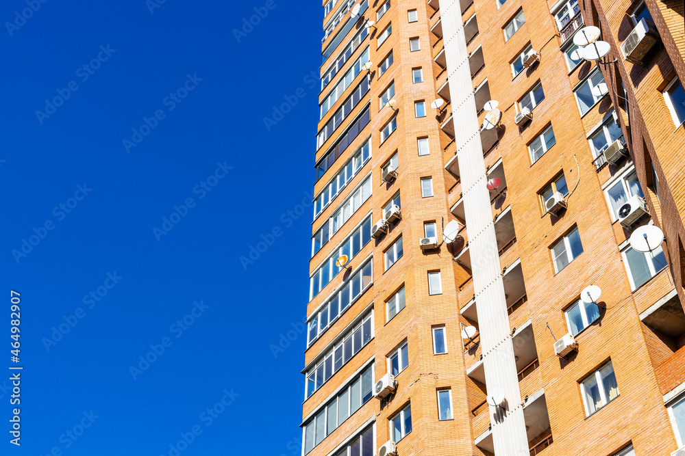 Fototapeta premium high-rise apartment house and blue sky on sunny day