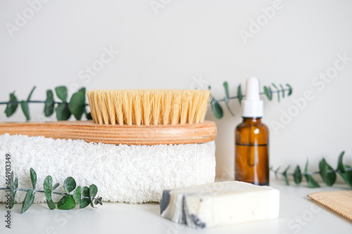 Massage wooden body brush on the background of spa items. Homemade body care. Dry lymphatic drainage massage and spa treatments.