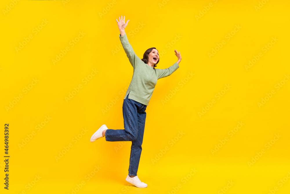 Full length body size view of attractive cheerful carefree middle-aged woman dancing fooling isolated over shine yellow color background
