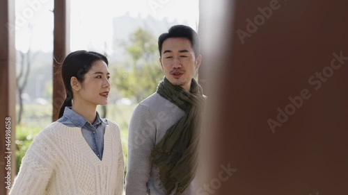 young asian couple walking talking dating outdoors in park photo