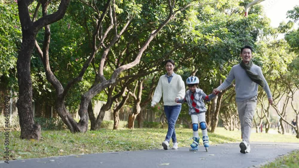 little asian boy learning roller skating outdoors in park with help from young parents little asian boy learning roller skating outdoors in park with help from young parents