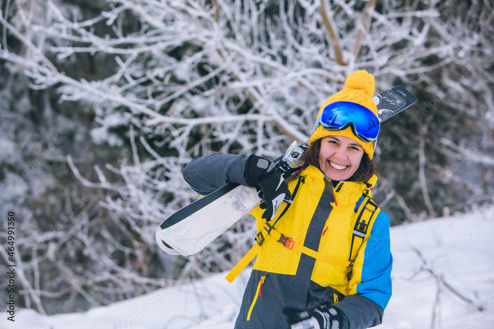 smiling gorgeous woman holding ski on shoulder