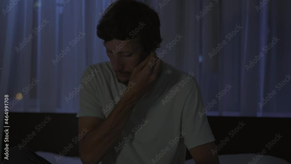 A man at night turns on a meditation, relaxation application on his phone to relax before going to bed. Antistress apps. Healthy lifestyle. New normal A man at night turns on a meditation, relaxation application on his phone to relax before going to bed. Antistress apps. Healthy lifestyle. New normal
