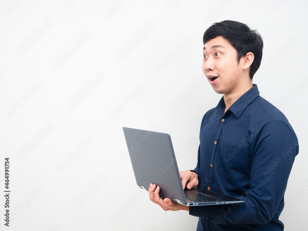Man holding laptop feeling amazed looking at copy sapce Man holding laptop feeling amazed looking at copy sapce