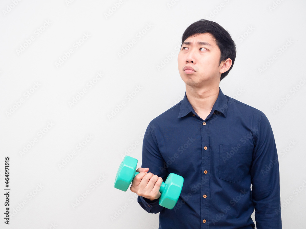 Man lazy emotion holding dumbbell looking at copy space Man lazy emotion holding dumbbell looking at copy space