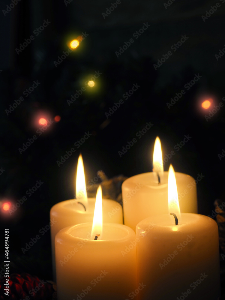 Close up of four burning Advent candles in a dark living room